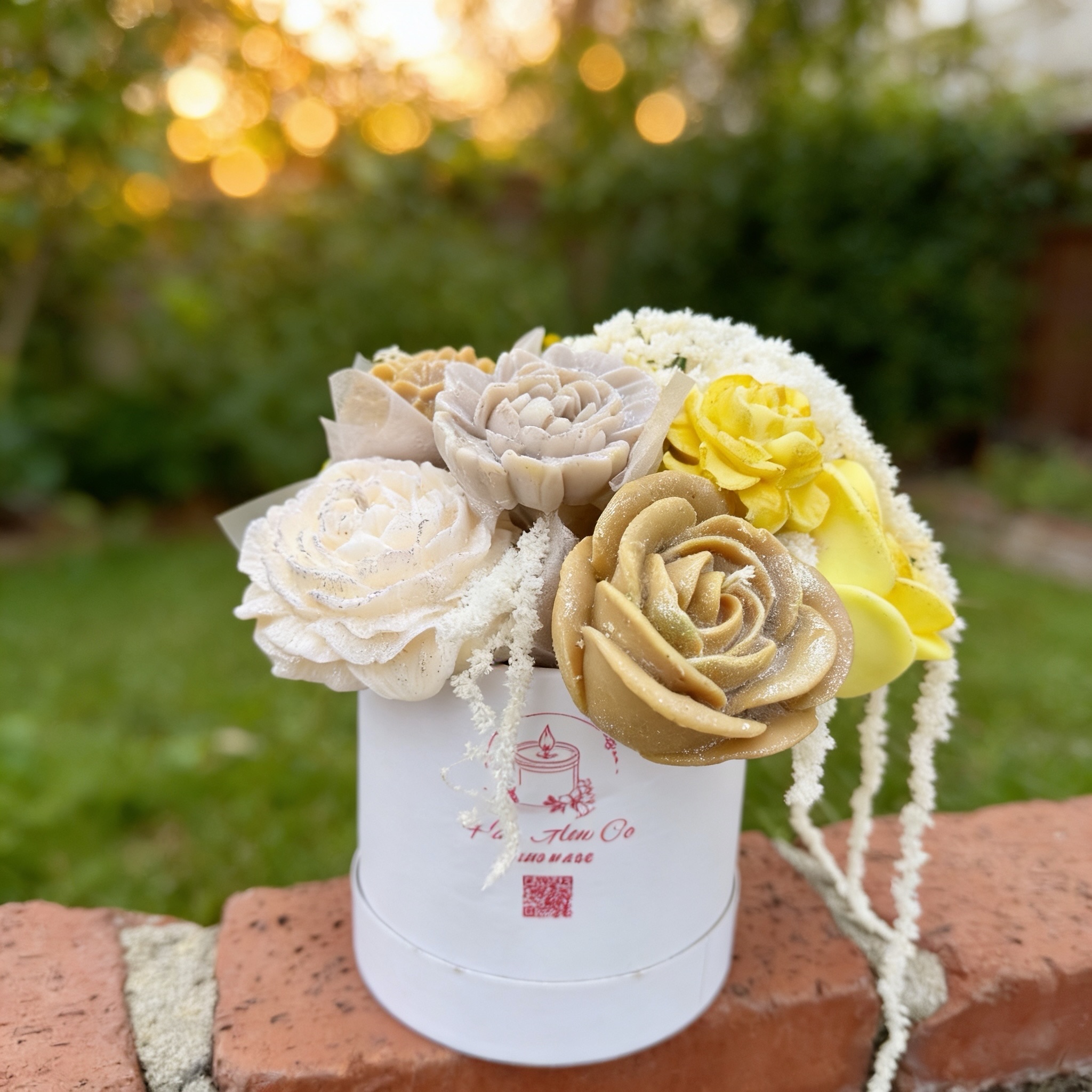 White and yellow sculpted rose candles in a branded gift box